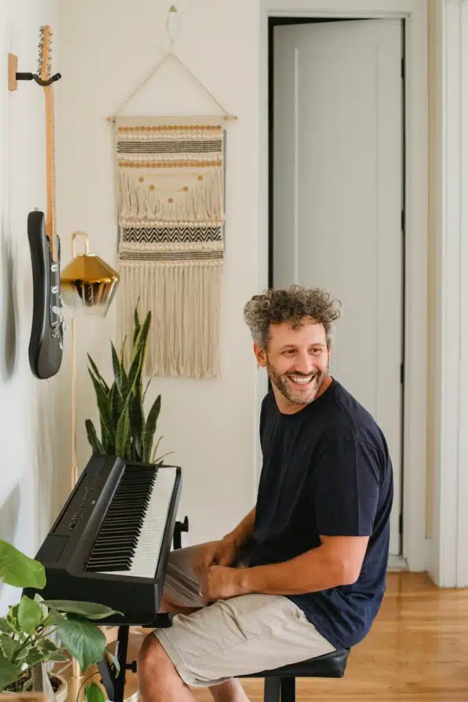grey haired older musician sitting in front of keyboard